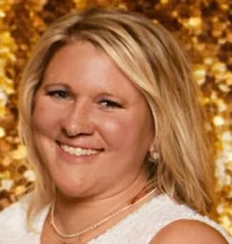 Smiling blonde woman against a gold background for Tidy TinkerBell in McKinney, TX.